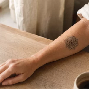 Unterarm Tattoo Frau mit filigranem Mandala-Motiv im Morgenlicht
