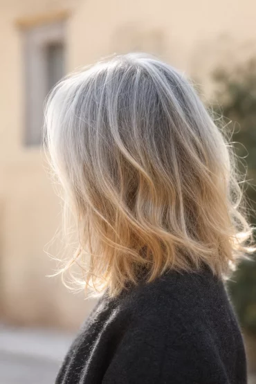 Balayage in weißem Haar mit weichem, natürlichem Verlauf im Sonnenlicht